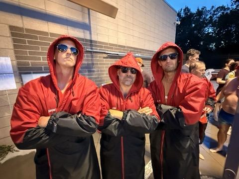 Three Louisvillains in red team parkas and sunglasses, arms folded